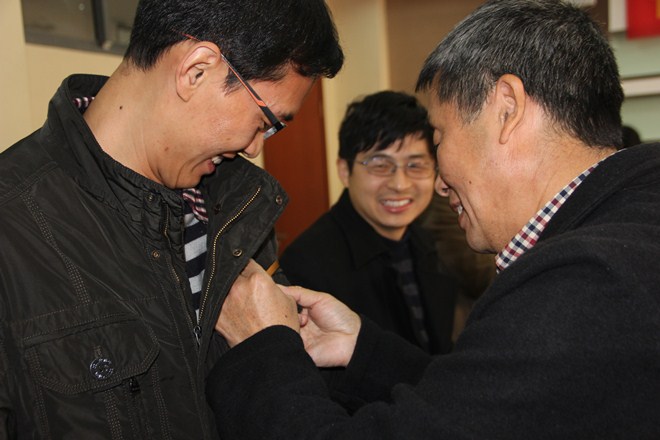 老教师为新教师佩戴校徽