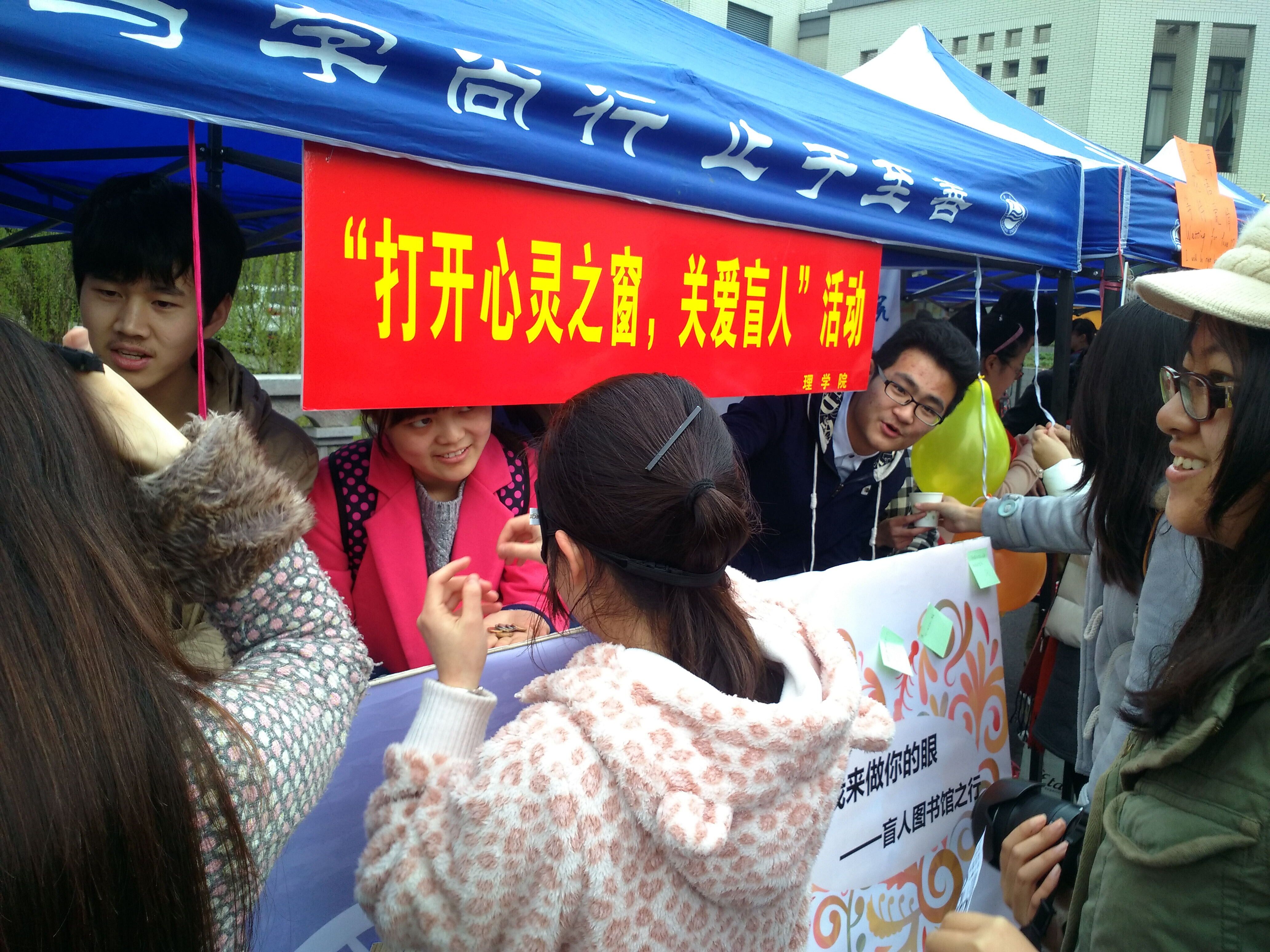 志愿者热情招呼行人关注宣传活动