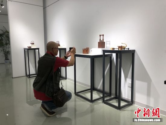 观展嘉宾拿出手机拍摄这些展出的作品。