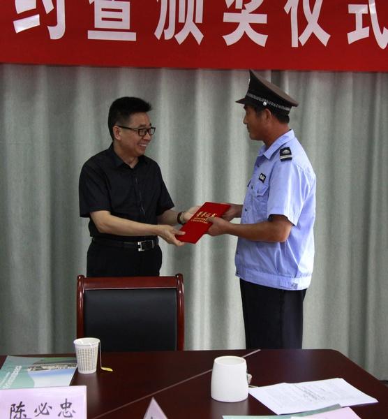 王轩董事长为抓获重大自行车盗窃案件嫌疑人的保安队员陈必忠颁发“见义勇为奖”荣誉证书和奖金