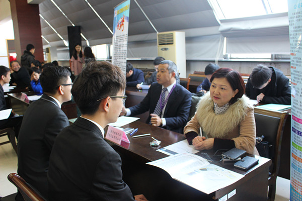 应届生们与双选会上的企业代表交流