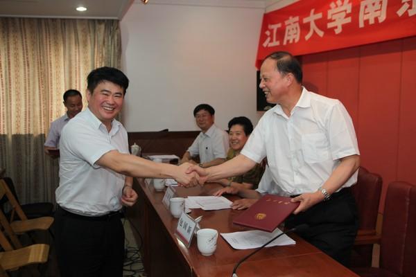 新任会长金明向名誉会长包国新发放聘书
