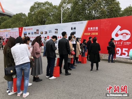 图为排队等候拍照“打卡”的校友们。