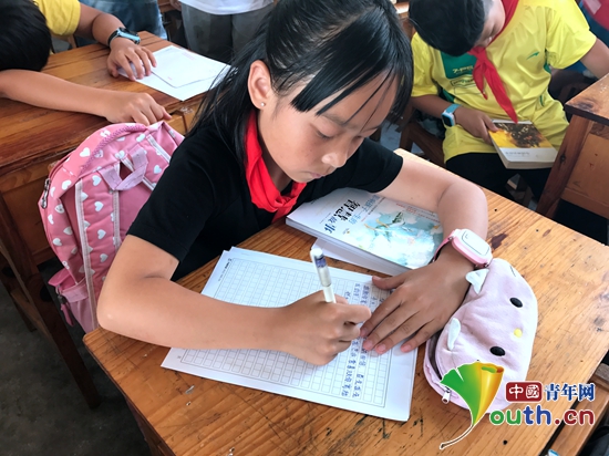 图为冯井中心小学五年级（2）班学生收到远方笔友赠送的书籍后书写回信。潘妍如 供图