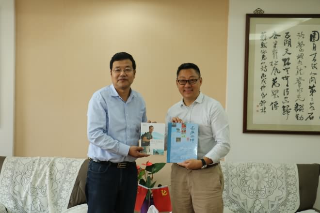 副校长纪志成与周成刚先生互赠书籍
